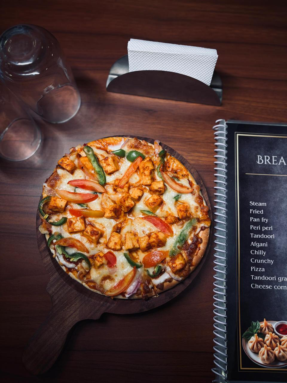 Freshly baked paneer pizza on a wooden board at Break A Leg cafe, Palghar